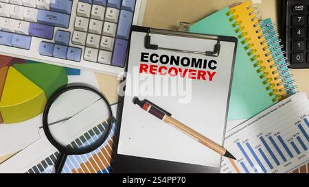 Concept of Economic Recovery write on paperwork isolated on Wooden Table. Stock Photo