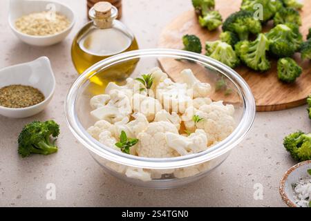 Bowl of cauliflower with broccoli, ready to be roasted, cooking with vegetables concept Stock Photo