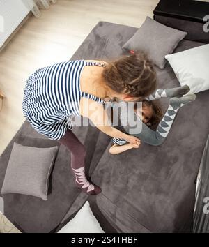 Photo of two sisters fighting on couch Stock Photo