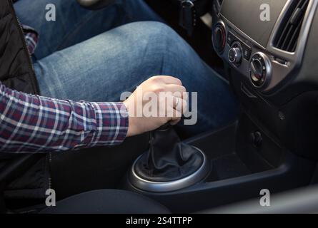 Closeup shot of young man shifting manual gearbox in car Stock Photo