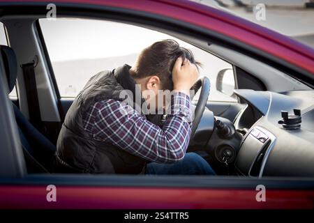 Portrait of stressed man sitting on car drivers seat Stock Photo