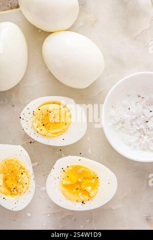 Soft boiled eggs cut in half with salt and black pepper Stock Photo
