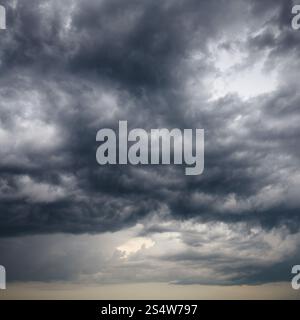 heavy low storm clouds in evening spring sky Stock Photo