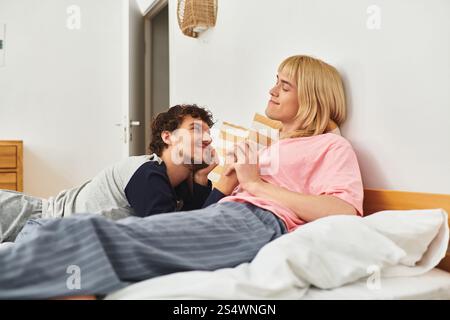 Two gay men share a tender moment in their serene bedroom, expressing deep affection and joy. Stock Photo
