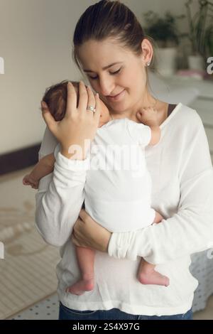 Portrait of young happy mother holding newborn baby boy Stock Photo