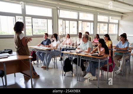 Classroom discussion with a teacher and attentive students during a lesson. Stock Photo
