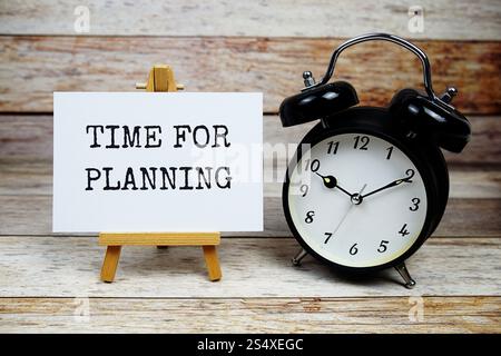 Time for Planning text written on paper card with alarm clcok on wooden background Stock Photo