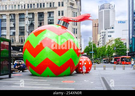 Giant festive ornaments on Queen Street, Auckland, New Zealand, showcasing vibrant Christmas decorations in the city's bustling downtown. Stock Photo