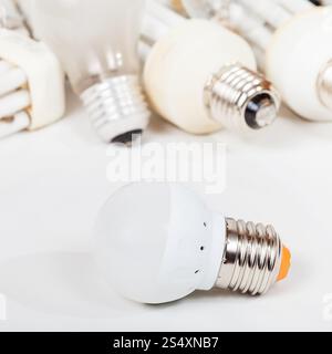 one new LED lamp and several old incandescent light bulbs and used compact Fluorescent lamps Stock Photo