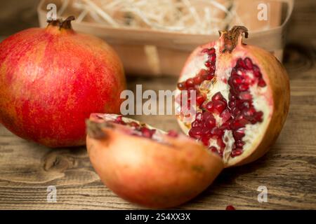 Closeup photo of two halves of pomegranate on old wooden board Stock Photo