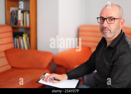 A calm office setting allows the consultant to focus, taking notes as they engage in thoughtful, client-centered conversations Stock Photo