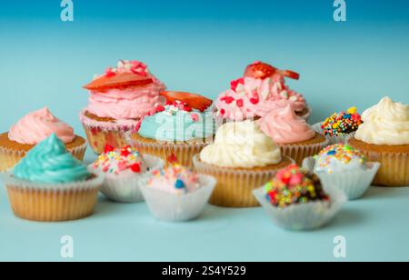 Closeup photo of homemade colorful cupcakes and candies on blue background Stock Photo