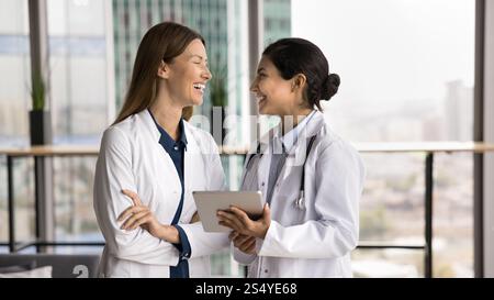 Two doctors laughing while lead informal conversation during break Stock Photo