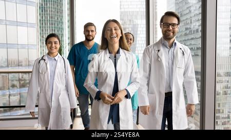 Five doctors in uniforms posing for cam in clinic office Stock Photo