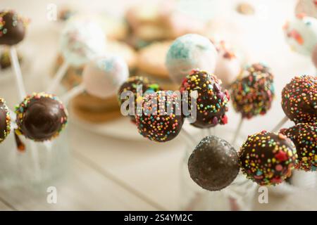 Decorated cake pops in cups on wooden table Stock Photo