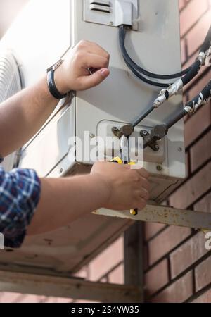 Closeup of worker connecting pipes to air conditioning system Stock Photo