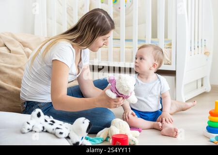 Baby boy playing on floor at living room with mother Stock Photo