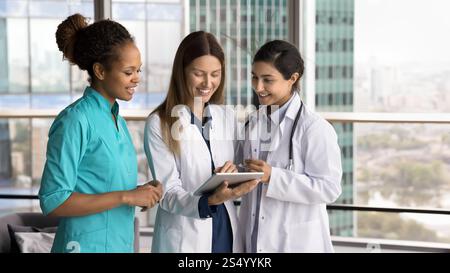 Three medical professionals gathered around digital tablet Stock Photo