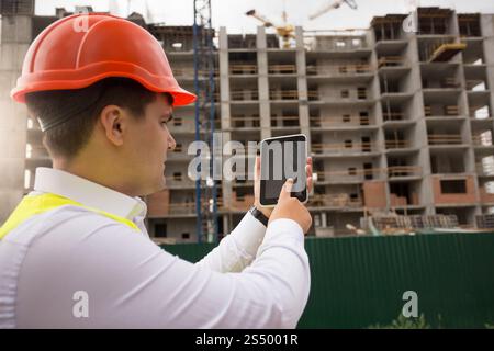 Young construction engineer using digital tablet on building site Stock Photo