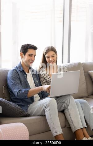 Positive young Hispanic couple using online application Stock Photo