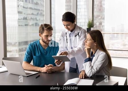 Three multinational doctors working together using digital tablet Stock Photo