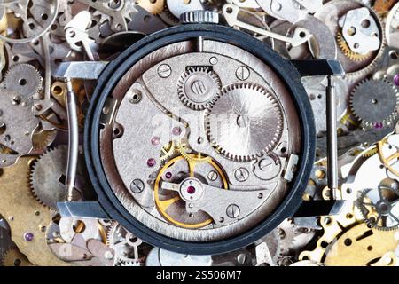 watchmaker workshop - open vintage watch on heap of clock spare parts Stock Photo