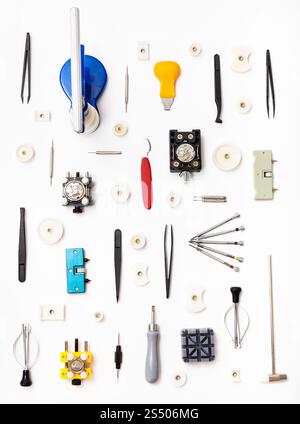watchmaker workshop - vertical ornament from various watch repairing tools on white background Stock Photo