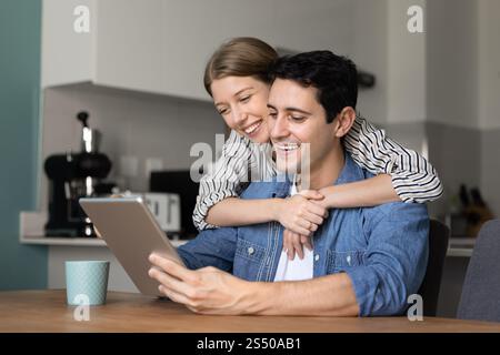 Cheerful attractive Hispanic couple using tablet computer Stock Photo