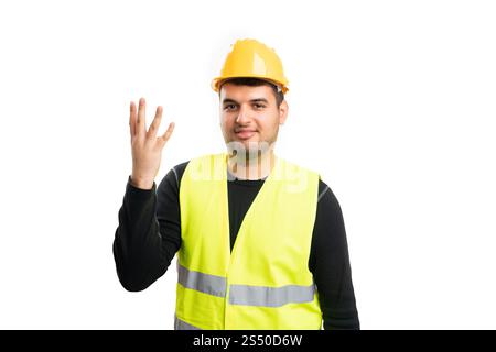 Constructor man in work attire helmet and vest making counting gesture with fingers showing number four or fourth concept isolated on white background Stock Photo