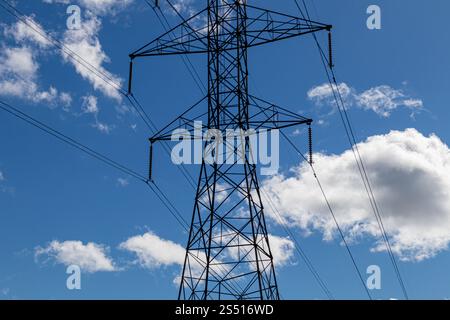 High voltage electrical tower and wires against blue sky Stock Photo