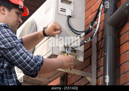 Closeup image of male repairman connecting air conditioner pipes and tubes. Closeup photo of male repairman connecting air conditioner pipes and tubes Stock Photo