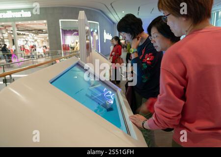 Shenzhen, China - February 06, 2019: women using self-service information kiosks at UpperHills shopping center. Stock Photo