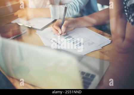 Business team meeting analysis financial chart together at cafe. Business team meeting analysis financial chart together at cafe.with reflection from Stock Photo