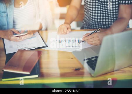Business team meeting analysis financial chart together at cafe. Business team meeting analysis financial chart together at cafe.with reflection from Stock Photo