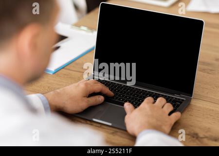 Man working on laptop with empty black screen for mockup Stock Photo