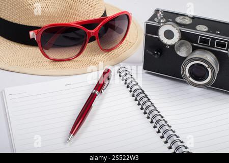 Camera Notepad Sunglasses and vintage camera with notepad isolated on a white b ...