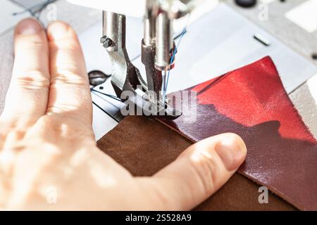 dressmaker sewing pieces of leather on sewing machine close up Stock Photo