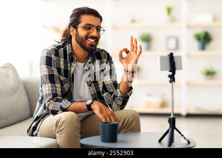 Cheerful indian guy with glasses blogger streaming from home Stock Photo
