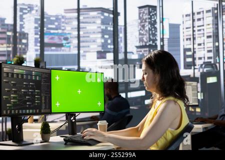 Admin utilizing green screen computer for cloud computing resources and platforms to train machine learning models. Woman monitoring and maintaining company systems using mockup PC Stock Photo