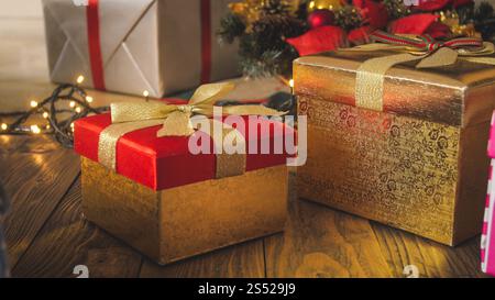 Closeup photo of red and golden gift boxes with ribbons for Christmas celebration. Closeup image of red and golden gift boxes with ribbons for Stock Photo