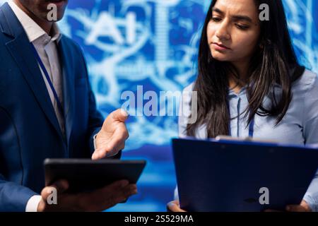 Admins use AI machine learning to extract information from complex data on tablet. Employees in workspace use artificial intelligence technology on device, comparing parameters, close up Stock Photo