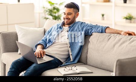 Smiling jewish man watching video on computer Stock Photo
