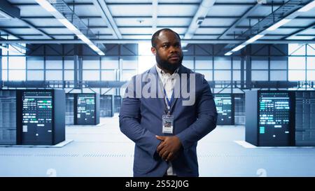 IT expert managing data center with advanced technology, ensuring cybersecurity and efficient network management. Admin in server room maintaining and optimizing data center infrastructure, camera B Stock Photo