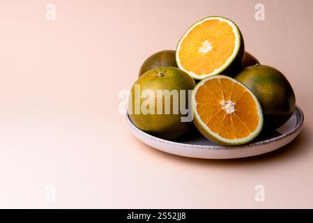Navel Chocolate Oranges on the plate. Chocolate orange, is a type of Navel orange, a mutation that was first discovered in 2006 in Valencia, Spain. Stock Photo