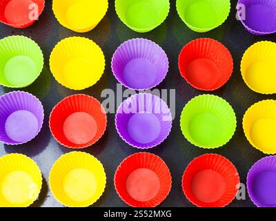 top view of many empty multicolored silicone molds for muffins on baking tray Stock Photo