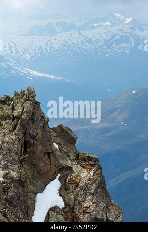 June view from the Karlesjoch Alps mountain (3108 m, near Kaunertal Gletscher on Austria-Italy border) over precipice and clouds. Stock Photo