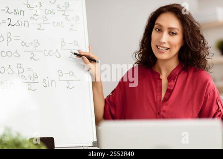 Lady teacher explaining trigonometric functions to students using pc Stock Photo