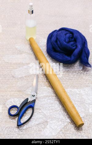 workshop of hand making a fleece gloves from Merino sheep wool using wet felting process - wool and set of tools to make felt on mat Stock Photo