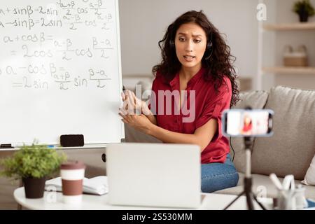 Lady teacher giving online lesson to students recording video Stock Photo