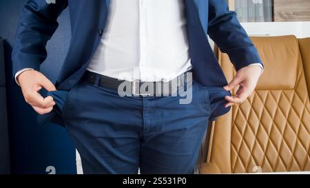 Closeup photo of businessman emptying hid pockets at office. Closeup image of businessman emptying hid pockets at office Stock Photo